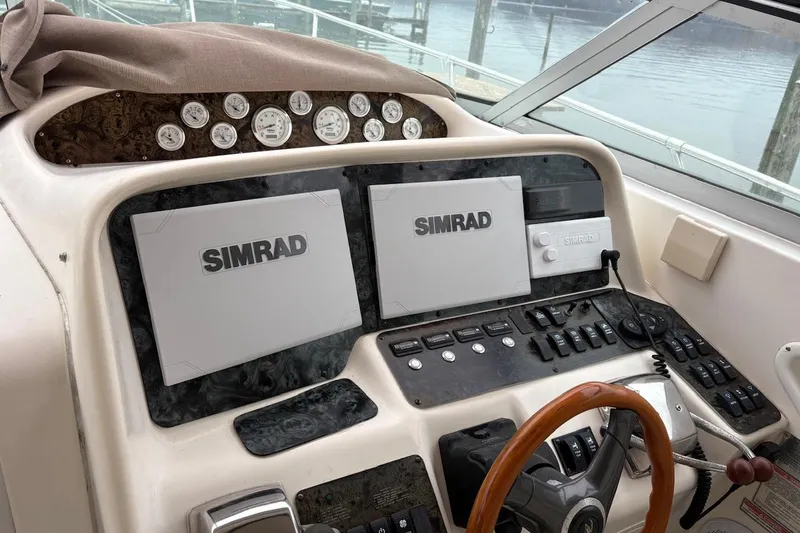 Slide: The Image of 1997 Sea Ray 330 Express Cruiser helm with Simrad navigation displays and gauges. - 26