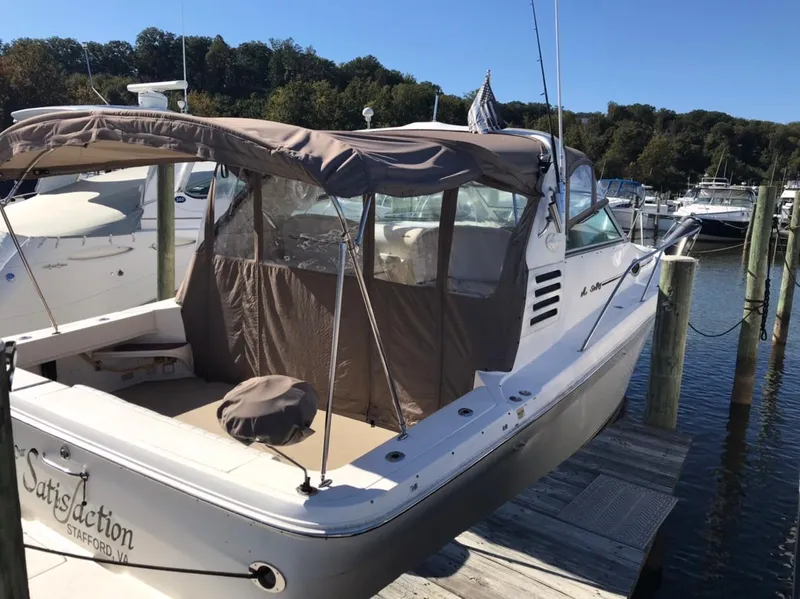 Slide: The Image of 1997 Sea Ray 330 Express Cruiser docked, featuring a beige canopy and spacious deck. - 5