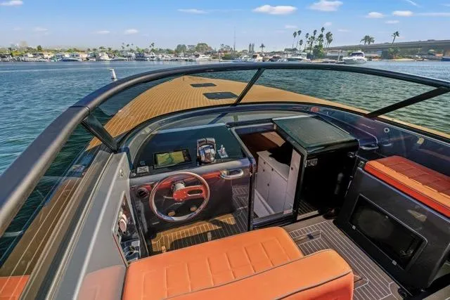 Slide: The Image of 2015 VanDutch 40 yacht interior with orange seating, steering wheel, and navigation equipment. - 23