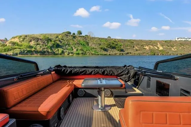 Slide: The Image of 2015 VanDutch 40 yacht interior with orange seating, table, and scenic water view. - 34