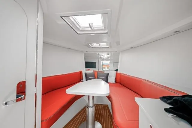 Slide: The Image of Interior of 2015 VanDutch 40 yacht with red seating and white table. - 49