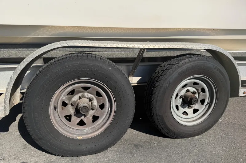 Slide: The Image of Trailer wheels of a 2018 Twin Vee 260 CC SE boat on pavement. - 22