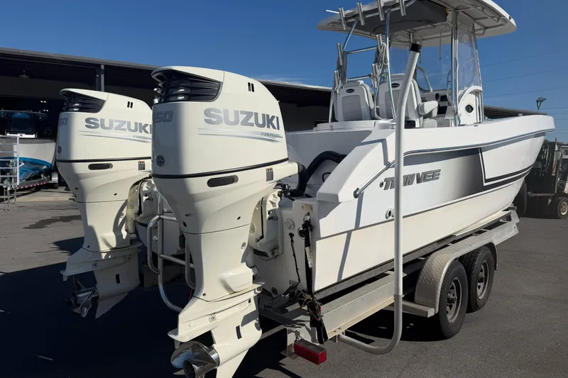Slide: The Image of 2018 Twin Vee 260 CC SE boat with dual Suzuki outboard motors on a trailer. - 24