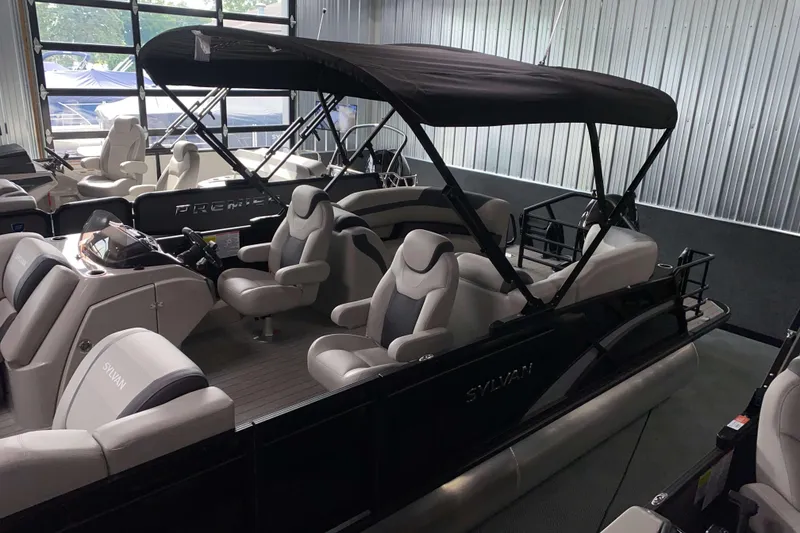 Slide: The Image of 2025 Sylvan L3 LZ pontoon boat with canopy and luxurious seating in showroom. - 14