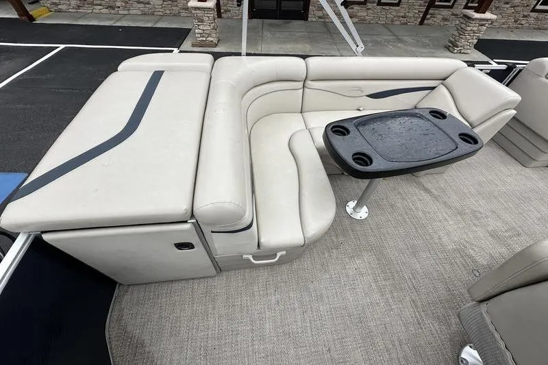 Slide: The Image of 2018 Bennington 21SLX boat interior with beige seating and a black table. - 14