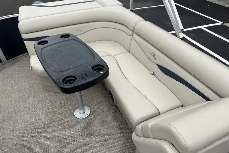 Slide: The Image of 2018 Bennington 21SLX boat interior with beige seating and black table. - 16