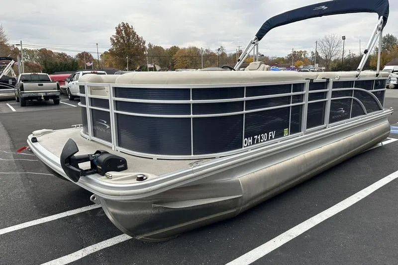Slide: The Image of 2018 Bennington 21SLX pontoon boat parked in a lot, featuring sleek design and blue accents. - 4
