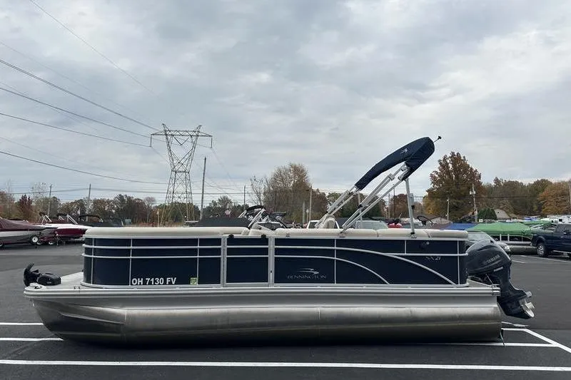 Slide: The Image of 2018 Bennington 21SLX pontoon boat parked in a lot under cloudy skies. - 6