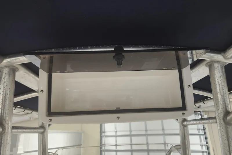 Slide: The Image of Interior of 2012 Edgewater 228CC boat showing storage compartment with blue hoses. - 14