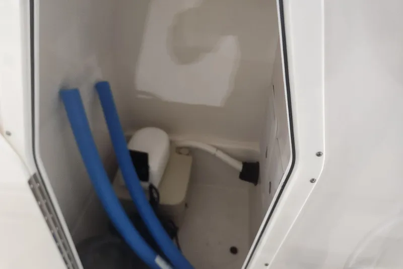 Slide: The Image of 2012 Edgewater 228CC boat interior with seating and canopy in showroom. - 15