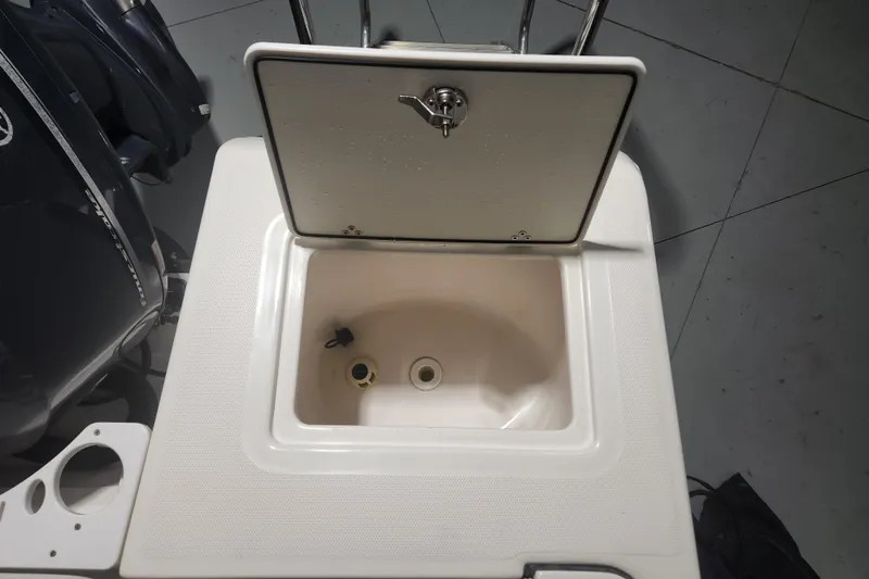 Slide: The Image of Open storage compartment on a 2012 Edgewater 228CC boat, featuring a Yamaha engine. - 22