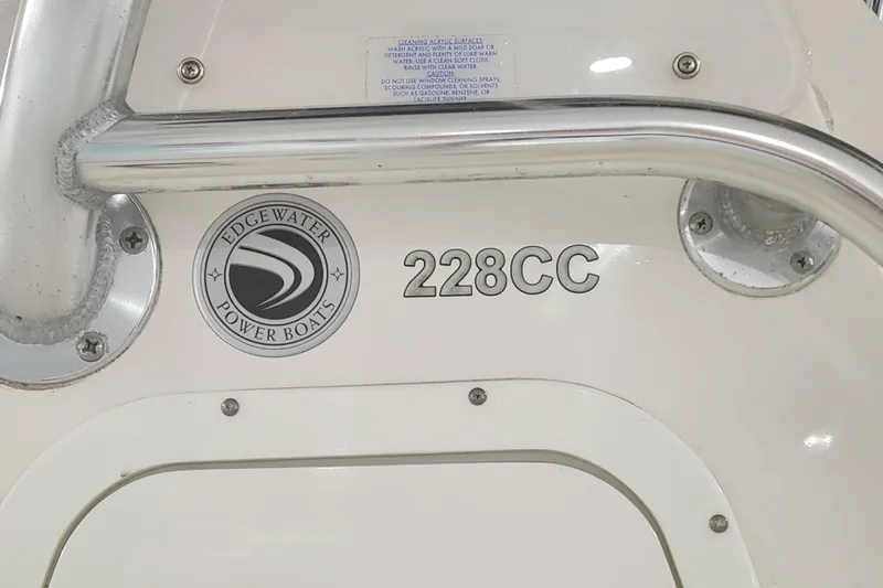 Slide: The Image of 2012 Edgewater 228CC boat displayed indoors, blue and white hull. - 3
