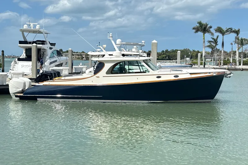 Slide: The Image of 2022 Hinckley 35 yacht docked in a sunny marina with palm trees. - 1