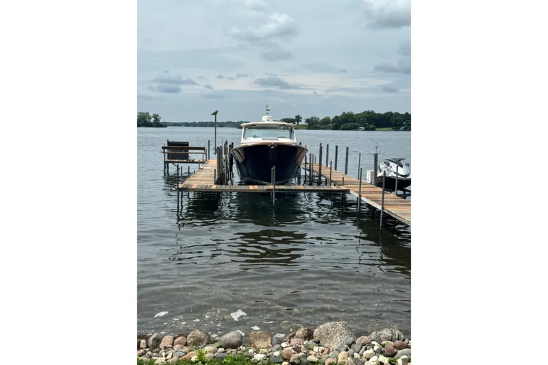 Slide: The Image of Hinckley 35 boat docked on a lake, 2022 model, with cloudy sky backdrop. - 2