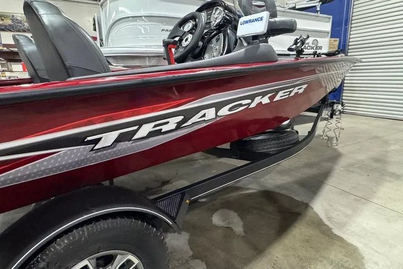Slide: The Image of 2021 Tracker Pro Team 175 TXW boat in showroom, featuring red exterior and Lowrance equipment. - 10