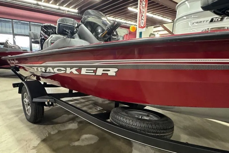 Slide: The Image of 2021 Tracker Pro Team 175 TXW boat in showroom, red exterior, on trailer. - 12