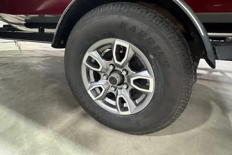 Slide: The Image of 2021 Tracker Pro Team 175 TXW trailer wheel with Karrier tire on concrete floor. - 22