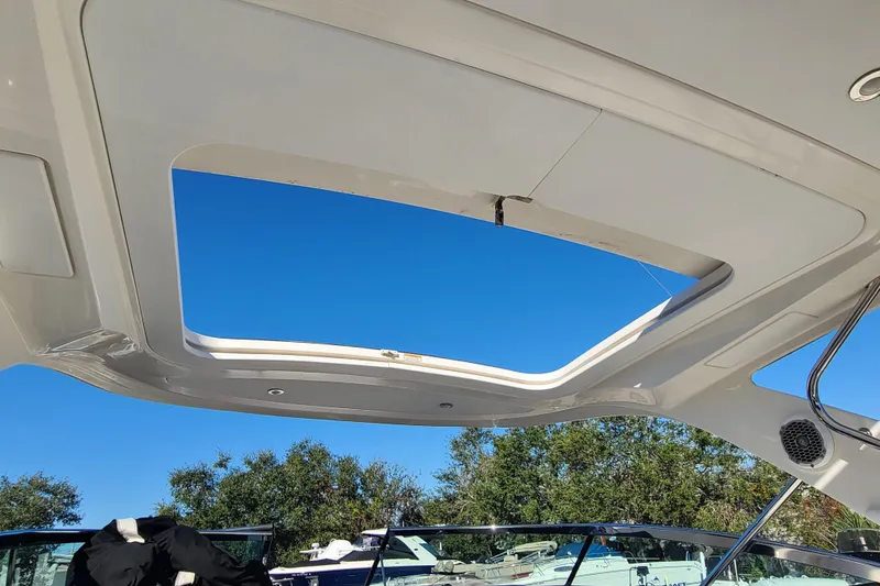 Slide: The Image of 2014 Sea Ray 350 SLX boat with open sunroof and clear blue sky. - 18