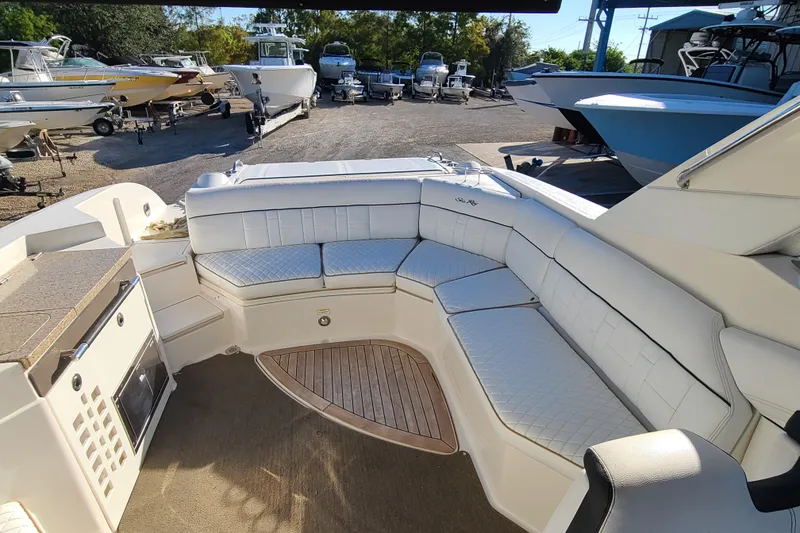 Slide: The Image of 2014 Sea Ray 350 SLX boat interior with white seating and wood flooring. - 19