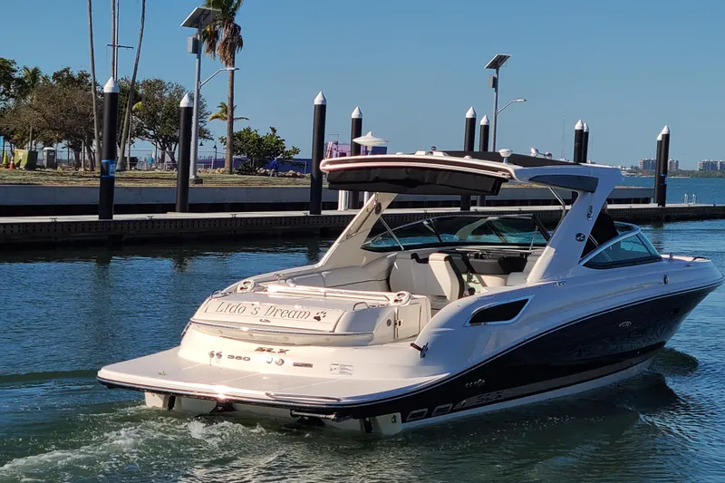 Slide: The Image of 2014 Sea Ray 350 SLX luxury boat docked in a sunny marina. - 2