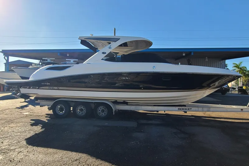 Slide: The Image of 2014 Sea Ray 350 SLX boat on trailer under clear blue sky. - 27