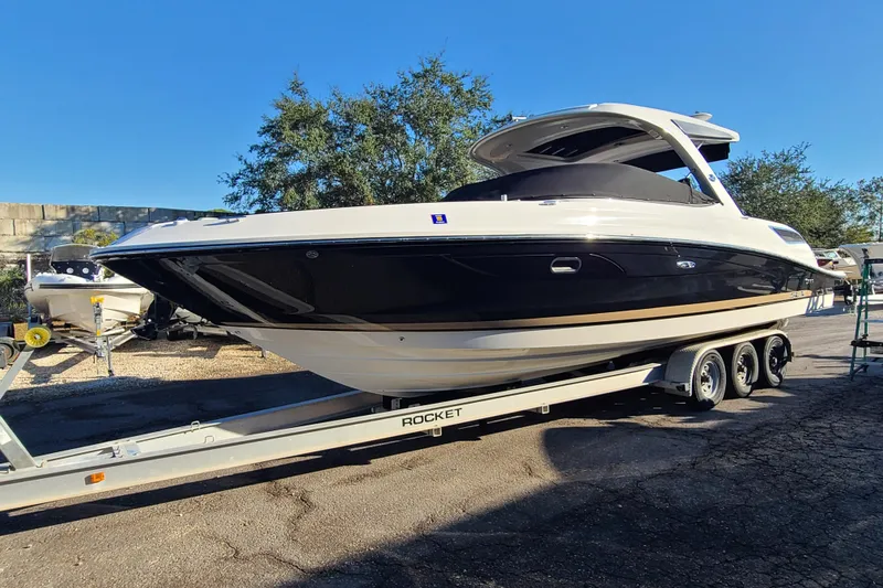 Slide: The Image of 2014 Sea Ray 350 SLX boat on trailer, parked outdoors under clear blue sky. - 29