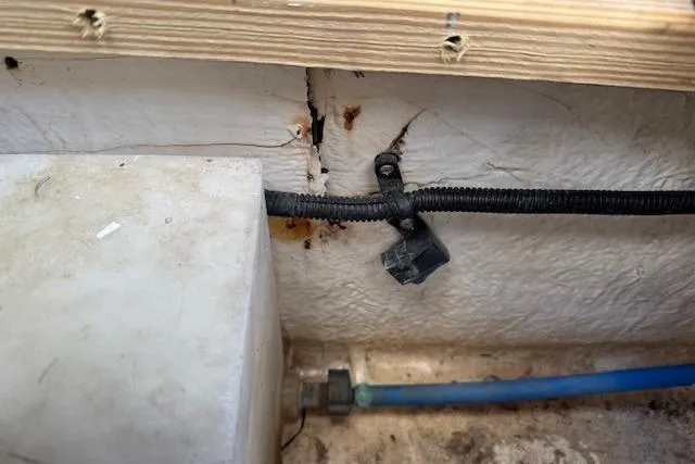 Slide: The Image of Cracked interior wall of 2014 Sea Ray SLX 350 boat with visible wiring and tubing. - 33