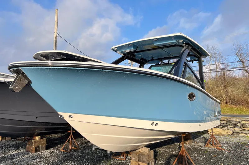 The Image of 2026 Robalo R257 Dual Console boat in blue, displayed outdoors on stands. - 0