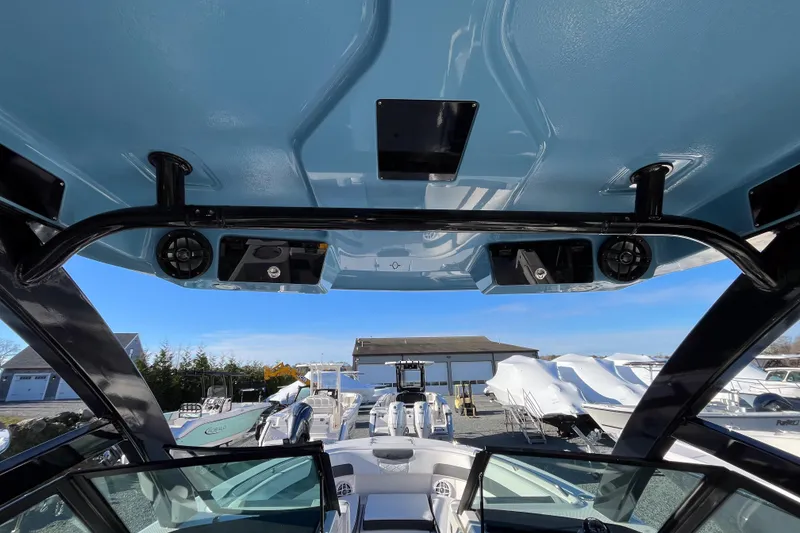 Slide: The Image of 2026 Robalo R257 Dual Console boat interior with speakers and blue canopy. - 17