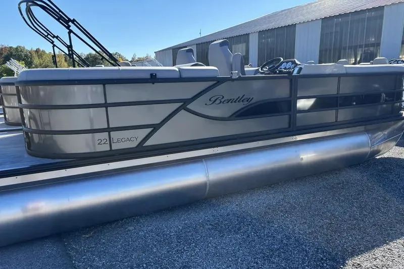 The Image of 2026 Bentley Pontoons Legacy 223 Navigator covered on trailer in grassy area. - 0