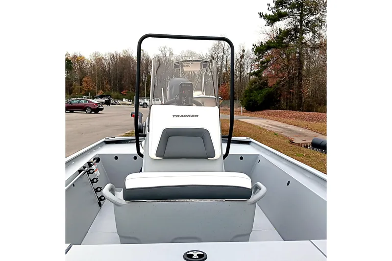 Slide: The Image of 2026 Tracker Bass Tracker Classic CC boat interior with seating and console, parked outdoors. - 10