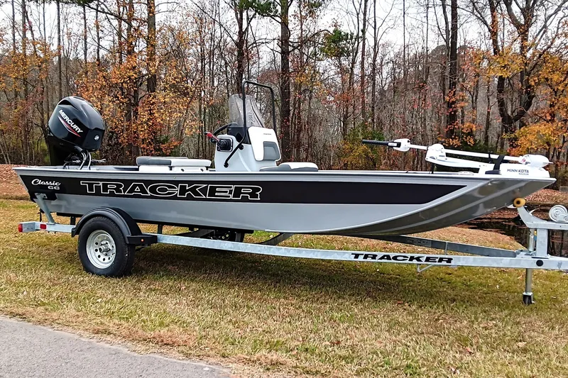 Slide: The Image of 2026 Tracker Bass Tracker Classic CC boat on trailer, parked in autumn forest setting. - 2