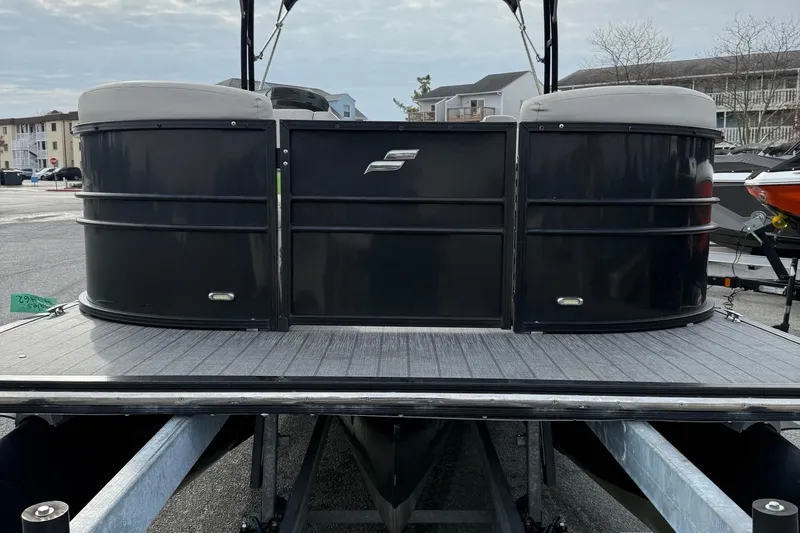 Slide: The Image of 2018 Starcraft SLS 5 pontoon boat, black exterior, docked in a marina. - 3
