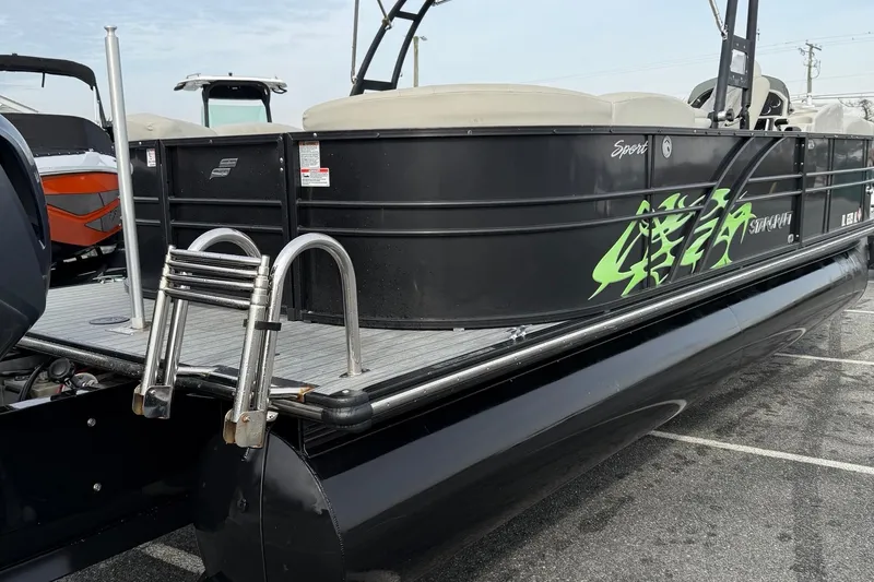 Slide: The Image of 2018 Starcraft SLS 5 pontoon boat with black exterior and green graphics. - 8