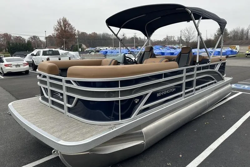 Slide: The Image of 2026 Bennington S Quad Bench 22 SSR pontoon boat with canopy in parking lot. - 7