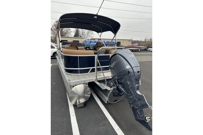 Slide: The Image of 2026 Bennington S Quad Bench 22 SSR pontoon boat with Yamaha outboard motor in parking lot. - 8