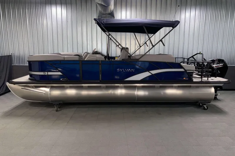 Slide: The Image of 2025 Sylvan L3 CLZ DH pontoon boat in showroom, blue exterior, canopy, and Mercury engine. - 16