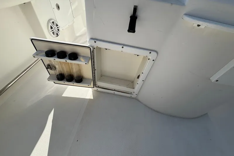 Slide: The Image of 2012 Sea Hunt Gamefish 29 boat storage compartment with open hatch and rod holders. - 14