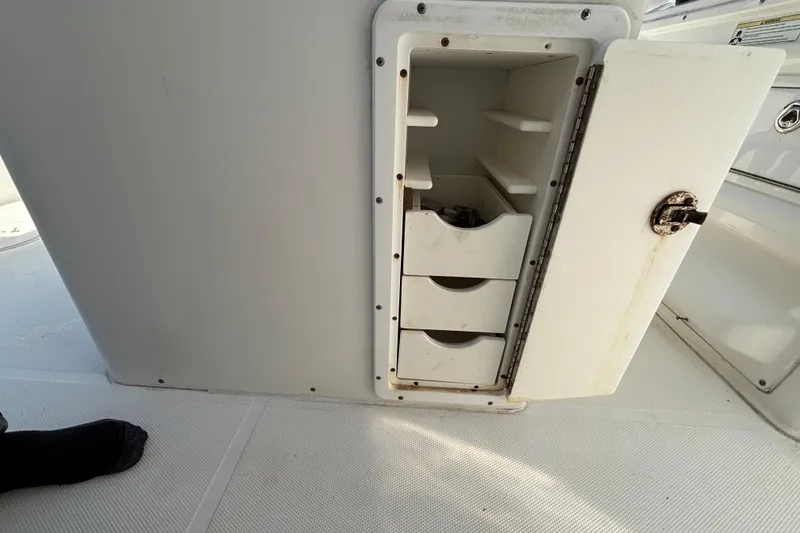 Slide: The Image of Open storage compartment on 2012 Sea Hunt Gamefish 29 boat with shelves and drawers. - 15