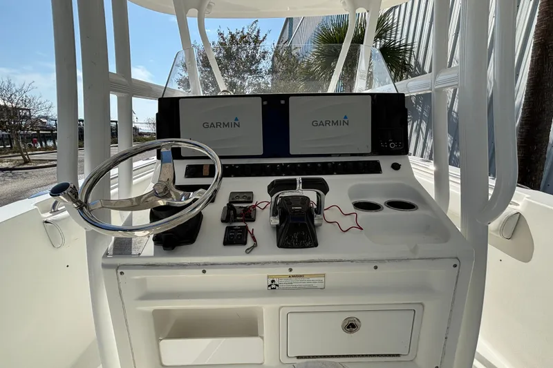 Slide: The Image of 2012 Sea Hunt Gamefish 29 boat console with Garmin navigation system and steering wheel. - 18