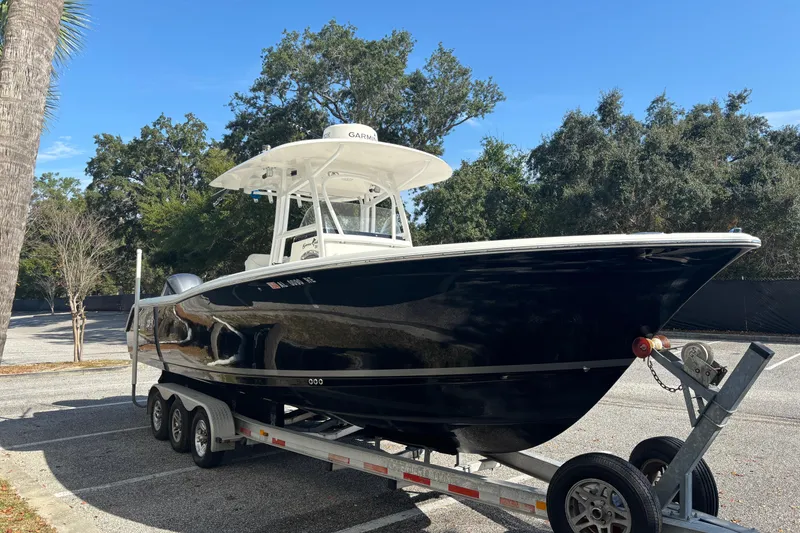 Slide: The Image of 2012 Sea Hunt Gamefish 29 boat on trailer, parked outdoors under clear sky. - 7