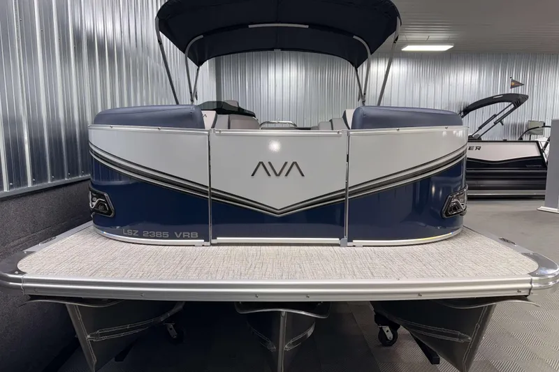 Slide: The Image of 2026 Avalon LSZ 2385 VRB pontoon boat in showroom, featuring sleek design and modern amenities. - 2