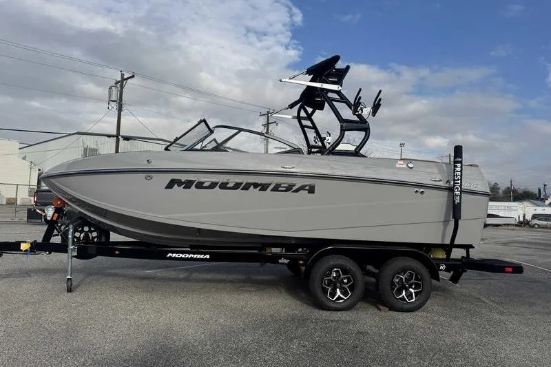The Image of 2026 Moomba Mondo boat on trailer, gray exterior, parked outdoors under cloudy sky. - 1
