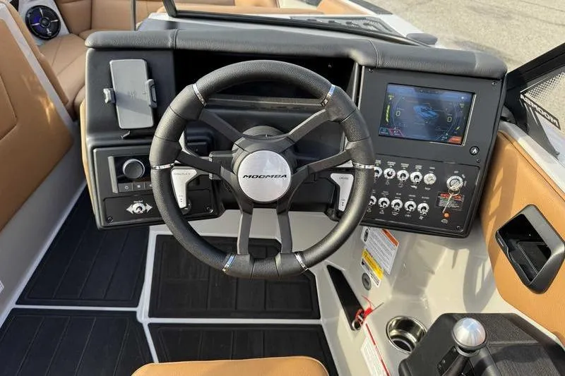 Slide: The Image of 2026 Moomba Mondo boat dashboard with steering wheel and control panel. - 14