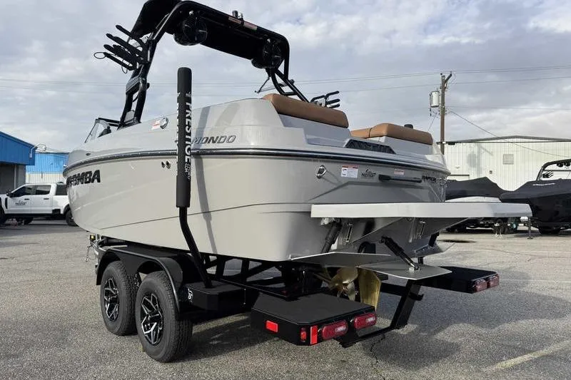 Slide: The Image of 2026 Moomba Mondo boat on trailer, rear view, parked outdoors. - 2