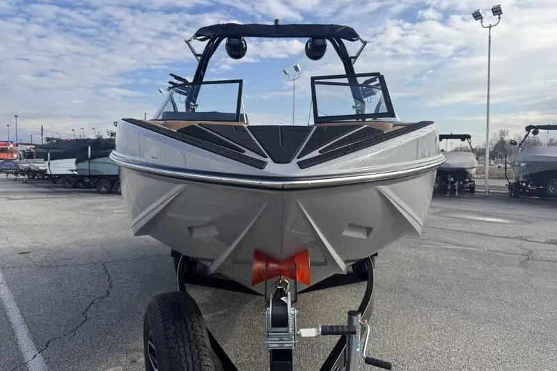 Slide: The Image of 2026 Moomba Mondo boat on trailer, front view, in a parking lot. - 6