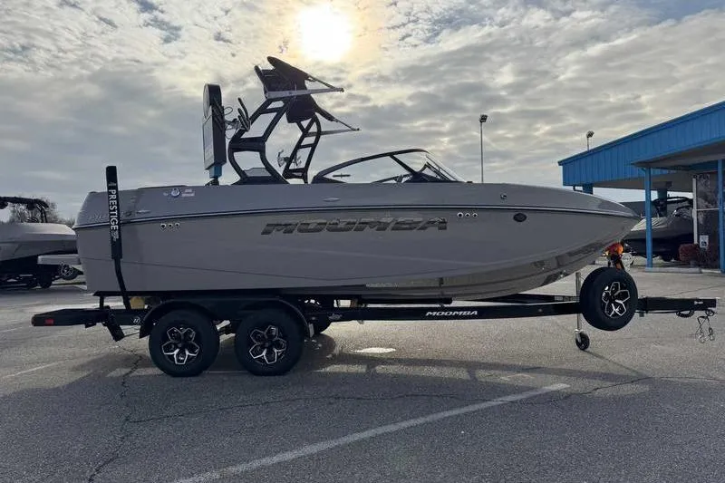 Slide: The Image of 2026 Moomba Mondo boat on trailer under cloudy sky in parking lot. - 8