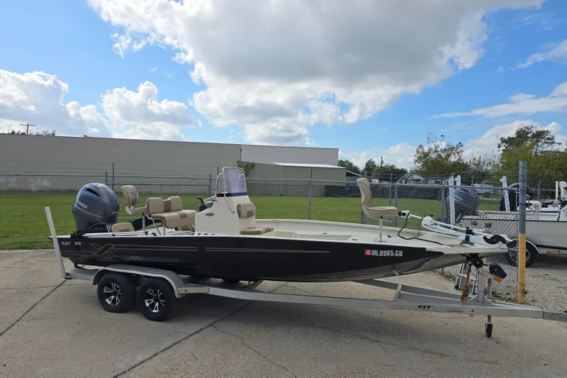 Slide: The Image of 2021 Xpress H22B Bay boat on trailer under cloudy sky. - 2