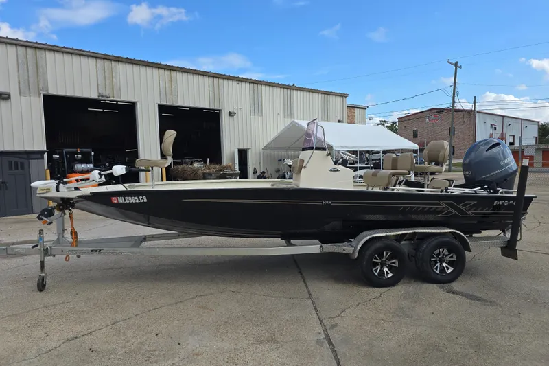Slide: The Image of 2021 Xpress H22B Bay boat on trailer, parked outside a warehouse. - 3