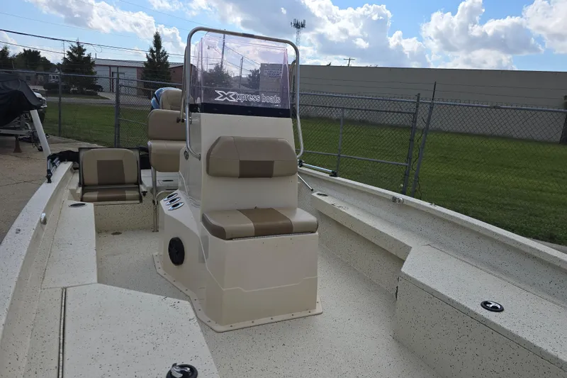 Slide: The Image of 2021 Xpress H22B Bay boat with seating, parked outdoors under a cloudy sky. - 6